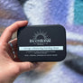 Hand holding a black box labeled 'incentival' with a blurred background