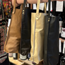 Four bags in different colors hanging on a rack with a blurred background.