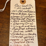A handwritten wine label tag on a wooden surface, detailing the production and flavor notes of a Barbadillo 'Mirabíos' 2007 wine from Palmito de Jerez, Spain.