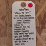 Tag with handwritten text on a wooden surface
