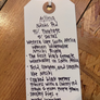 Handwritten tag on a wooden surface with text about a wine variety.