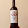 A bottle of Meritxell Palleja Nita Priorat red wine with a label featuring floral and fruit graphics.