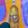 Bottle of Angelino Wine Company Albarino held against a colorful abstract background