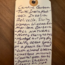 Handwritten tag with wine description on a wooden surface