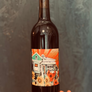 Wine bottle with a colorful label featuring a house and flowers against a dark background