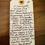 Handwritten tag on a wooden surface with product description