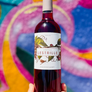 Bottle of Lestrille wine held against a colorful abstract background