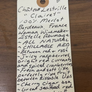 Handwritten wine label on a wooden surface