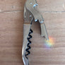Silver corkscrew on a wooden surface