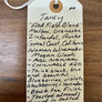 Handwritten wine label on a wooden surface