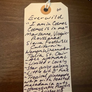 Handwritten tag with product details on a wooden surface