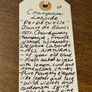 Handwritten tag on a wooden surface with product description