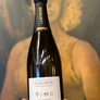 Bottle of Laborde champagne held in front of a blurred painting