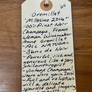 Handwritten wine tag on a wooden surface