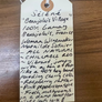 Handwritten tag on a wooden surface with wine description text.