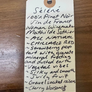 Handwritten wine description tag on a wooden surface