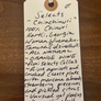 Handwritten tag on a wooden surface with product description text.