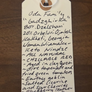 Handwritten tag with product details on a wooden surface