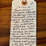 Handwritten tag on a wooden surface with wine description details.