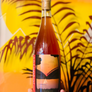 Bottle of wine held in front of a colorful abstract background