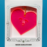 Neon pink heart-shaped suncatcher with a face design in a white box on a blue background