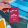 Red packet labeled 'Apéritif' held by a hand with a blurred background