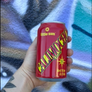 Red Calimocho can held in front of a colorful background