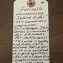 Handwritten wine label on a wooden surface