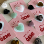 Pink cards with heart-shaped stones and 'you're a GEM!' text on a wooden surface.