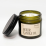 Green candle jar with lid and 'Queer Candle Co.' label on a white background