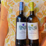 Two bottles of wine being held by a woman