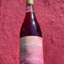 Bottle of Fossil and Fawn Pinot Gris wine in front of a pink background