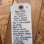 White tag with black text on a wooden surface