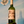 A hand holds a green glass bottle of Cava de Vinytes 'Casteille' white wine against a painted blue wall with a seagull mural.