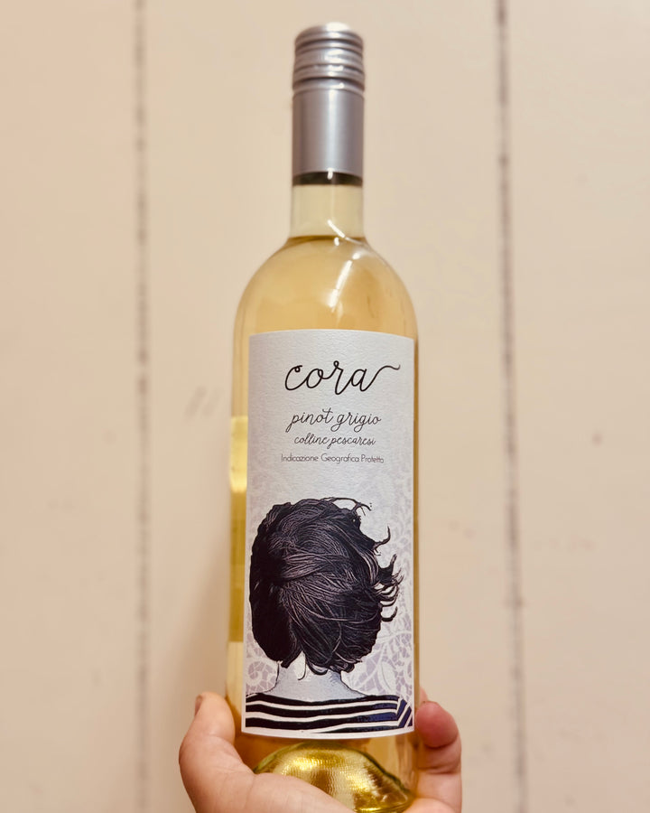 Wine bottle labeled 'cora' with a decorative label featuring a woman's silhouette against a beige background.