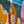Bottle of High Camp Wine sparkling wine held in front of a colorful abstract background