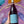 Bottle of High Camp Pinot Noir wine held by a person against a colorful abstract background