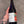 Hand holding a bottle of beer with a visible label against a neutral background