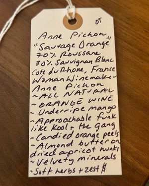Wine label with handwritten notes on a wooden surface