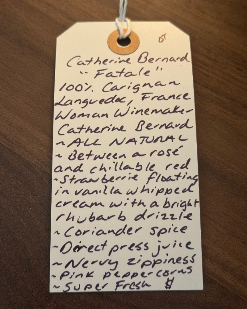 Handwritten tag with product description on a wooden surface