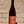 Wine bottle with decorative label featuring eyes and a mouth against a brick wall background