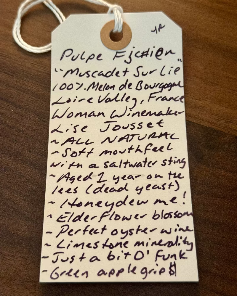 Handwritten wine label on a wooden surface