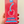 Hand holding a red packaging of 'The Official Cherry Emoji Vibrator' against a beige background