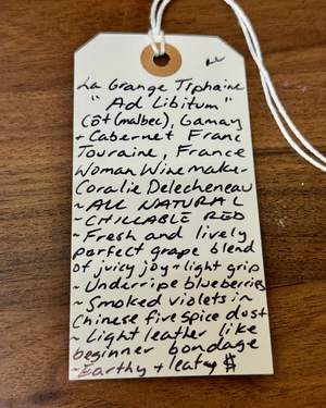 Handwritten wine label on a wooden surface