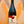 Wine bottle labeled 'Ad Libitum' held against a blurred orange background