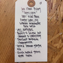 White tag with black text on a wooden surface
