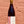Bottle of red wine labeled 'Le Jeune' held against a brick wall.