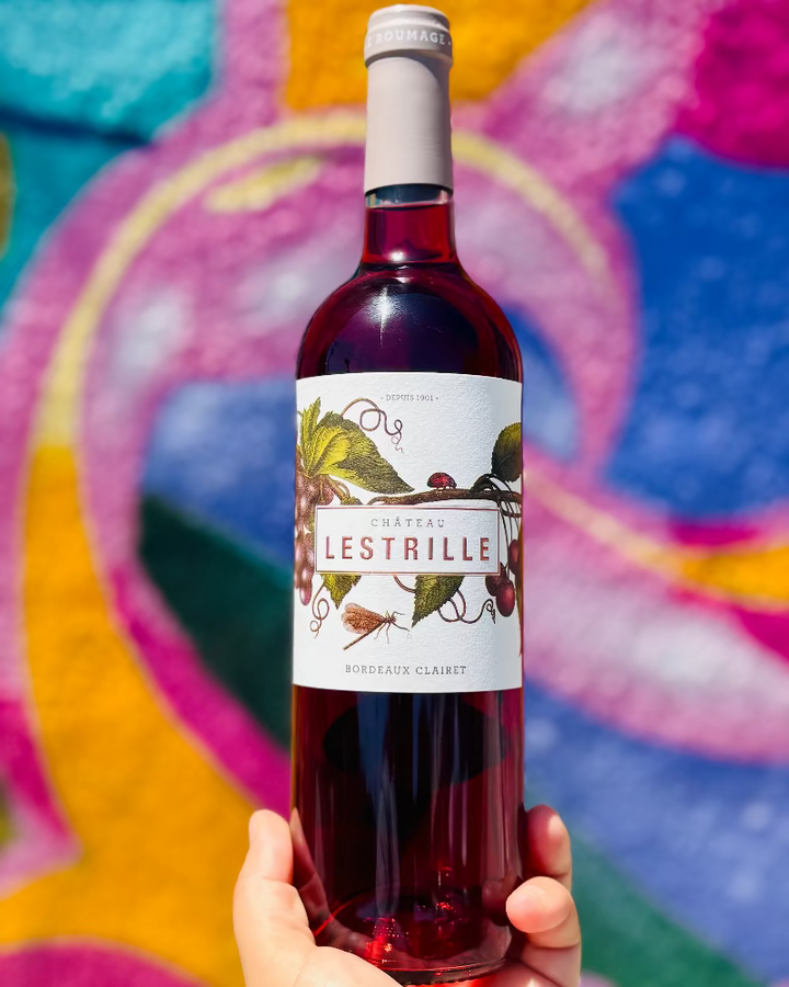 Bottle of Lestrille wine held against a colorful abstract background