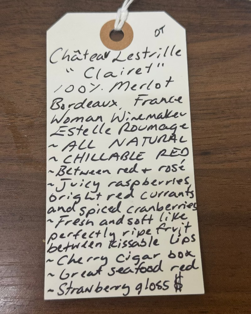 Handwritten wine label on a wooden surface