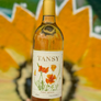 Bottle of Tansy wine with a floral label against a blurred natural background